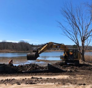 A backhoe at the end of a creek