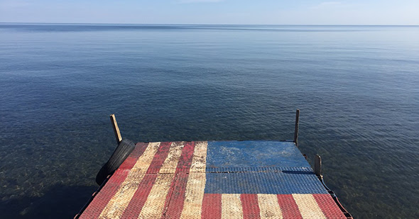 Dock with flag pattern and water to horizon