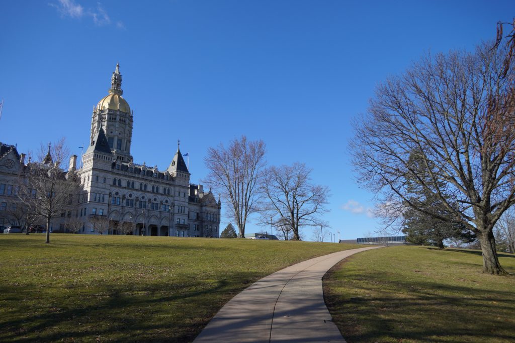 CT state capitol and grounds with green grass and bare trees